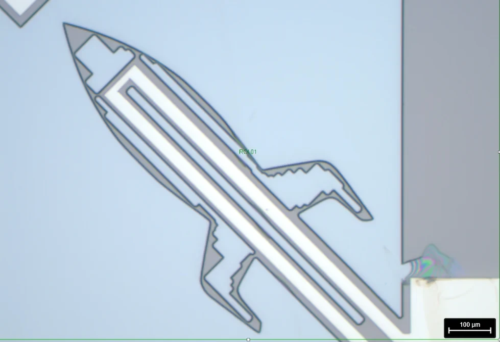 Microscope view of a released thermal micro-actuator shaped like a rocket: an oxide cantilever carrying a chromium heating track.