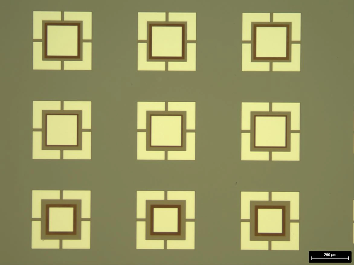 Microscope image of the finished MFMIS devices: square top electrodes of different areas over a common bottom electrode.